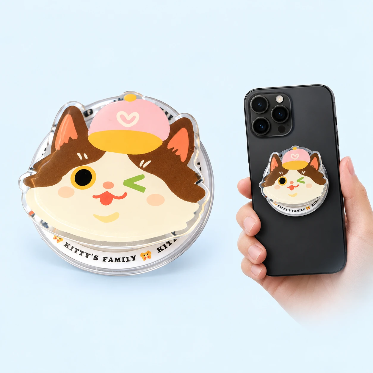 Winking cat magnetic phone grip on pale blue, product on left and attached to a hand-held phone on right