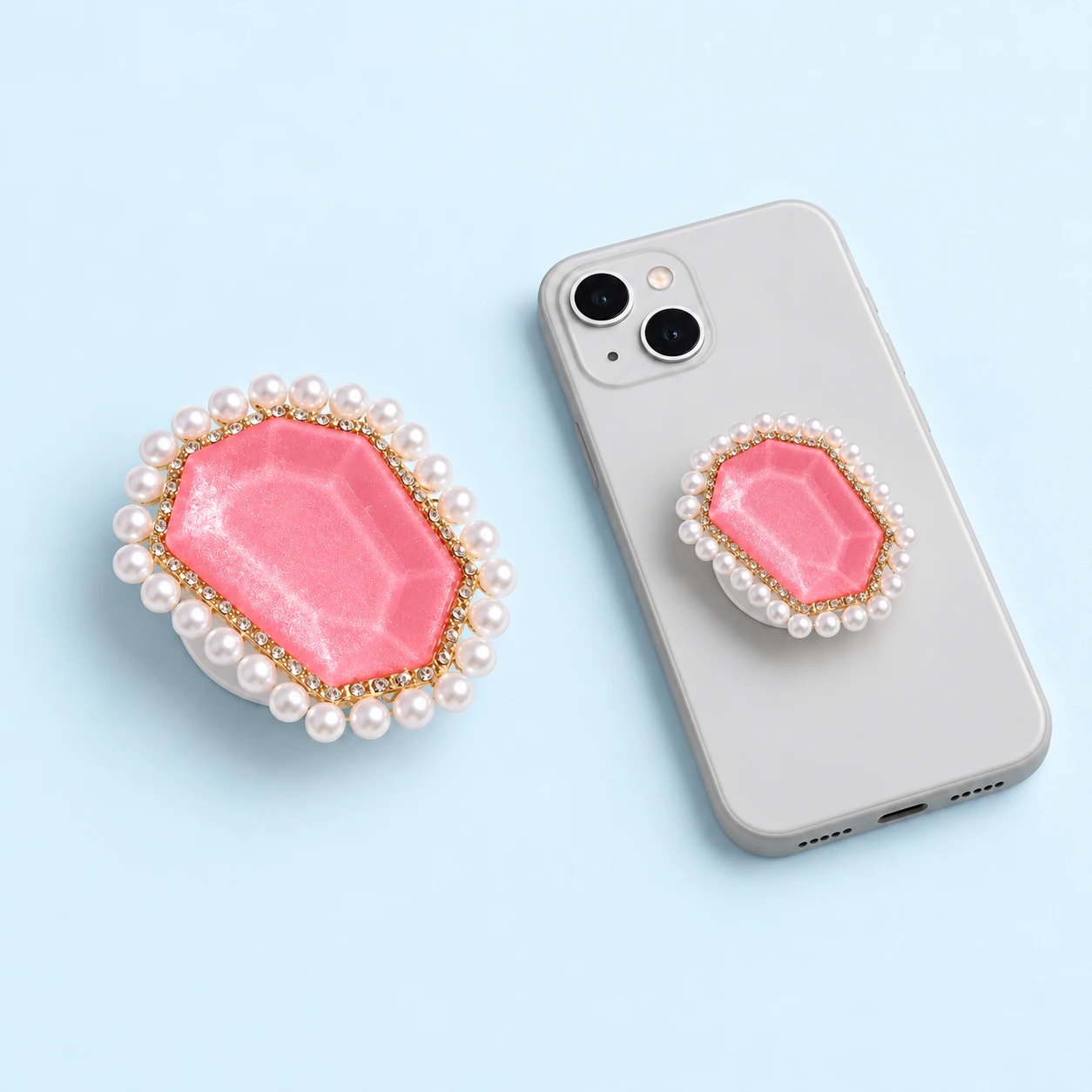 Pink geometric phone grip with pearl-effect border and closed phone-back mounting illustration, square composition