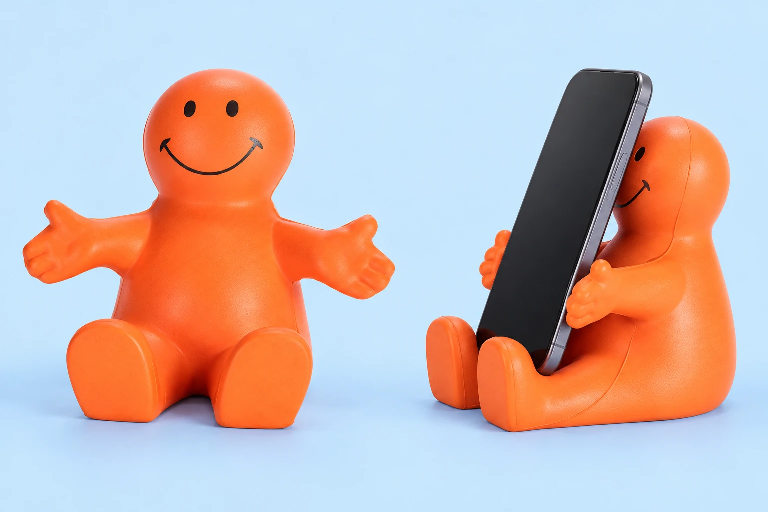 Orange smiling seated foam phone cradle, shown complete at left and in an illustrative portrait-phone resting arrangement at right; phone not included