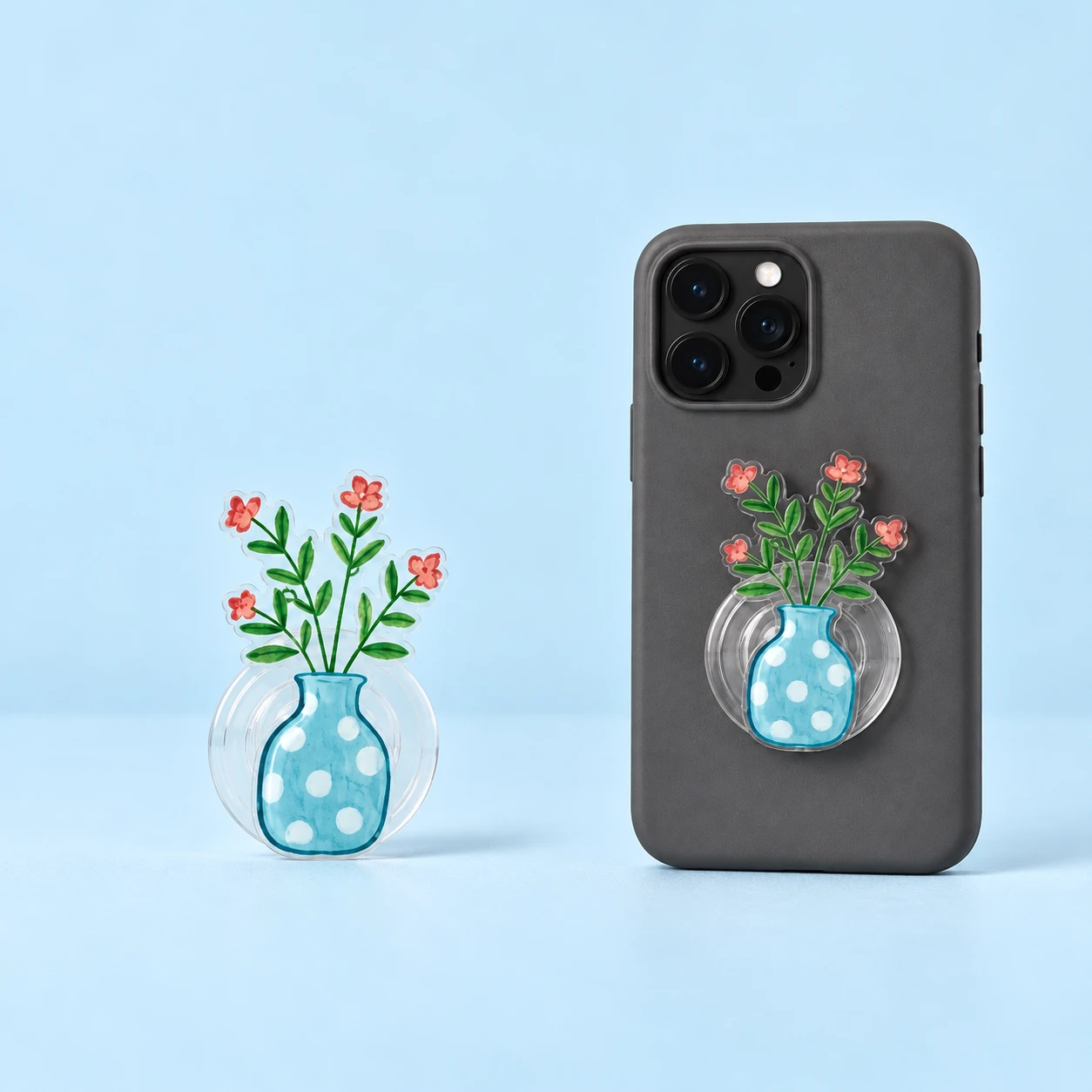 Blue polka-dot vase with four pink flowers expandable phone grip on a transparent circular base, square composition