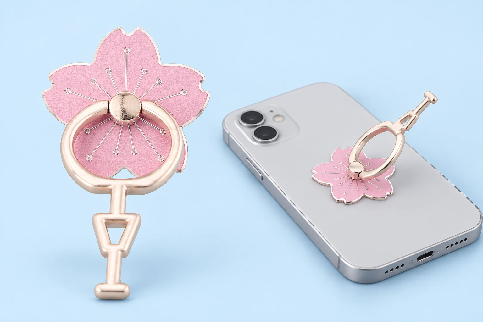 Light-pink cherry-blossom phone ring with its long continuous foot, complete and mounted on a flat-lying phone in a same-model use illustration