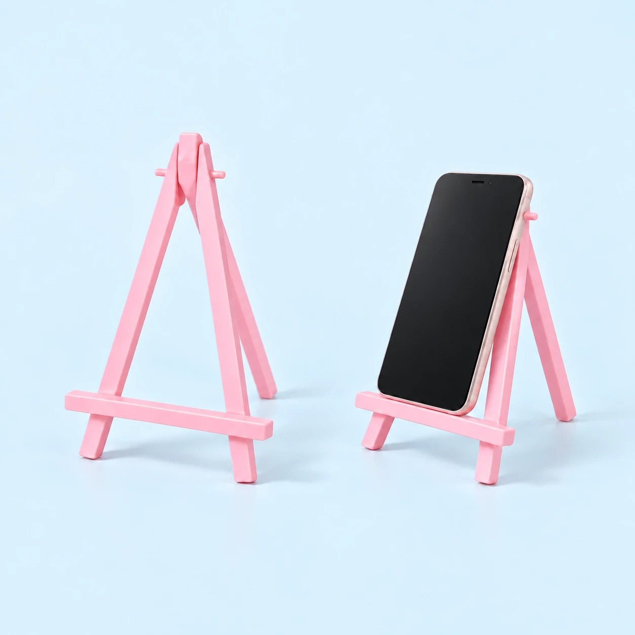 Pastel pink mini folding easel with triangular frame and illustrated phone placement, square composition