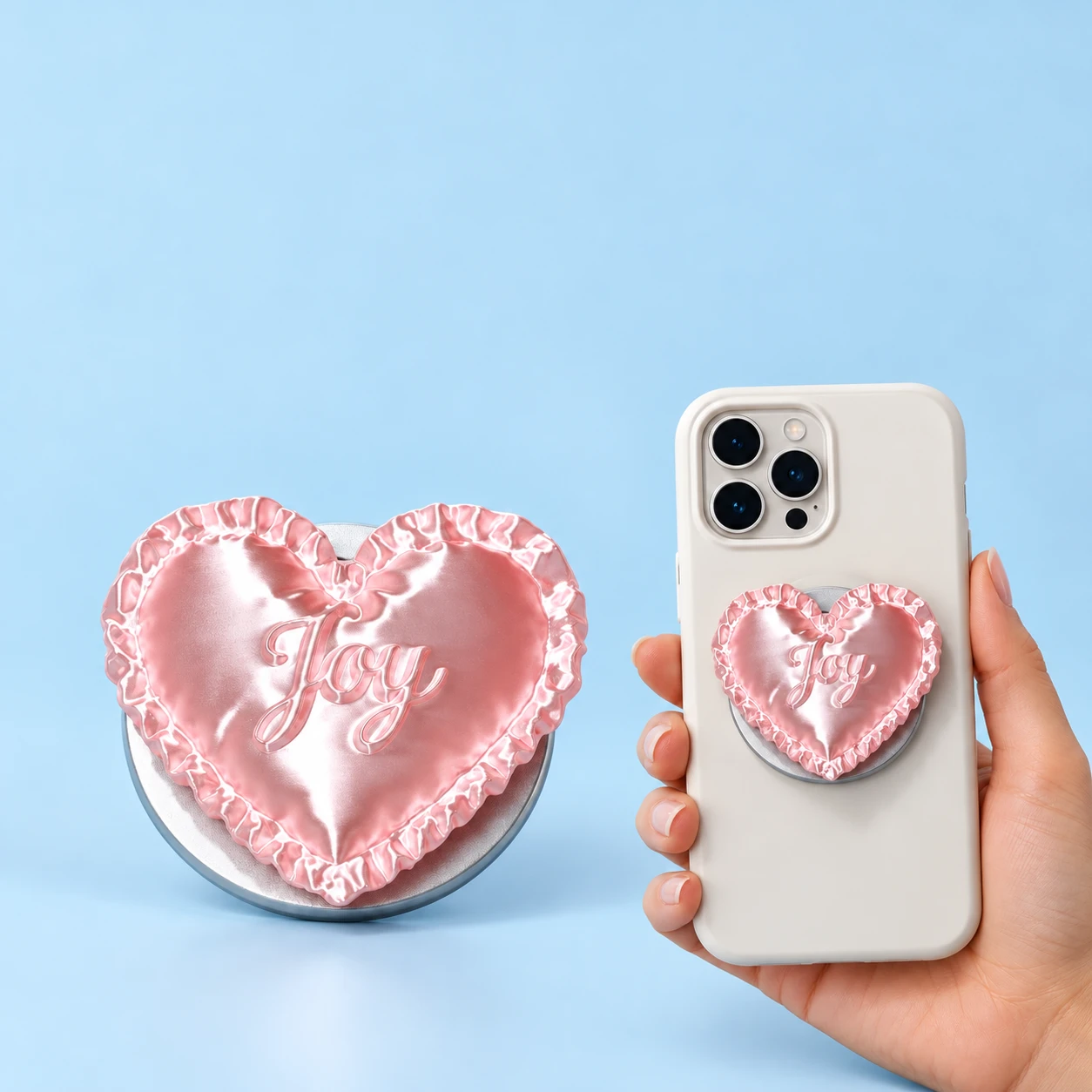 Pink ruffled heart magnetic phone grip with raised Joy lettering shown complete and mounted flat on a phone case, square composition