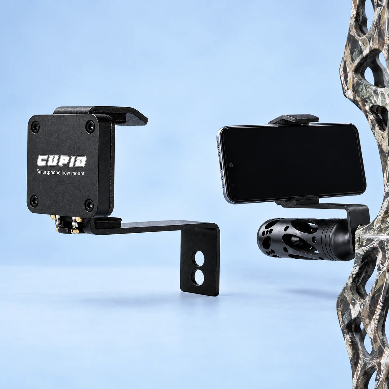 Complete black twin-spring phone mount with its original bent two-hole arm on the left; a horizontal demonstration phone held by the same mount on stationary cropped archery equipment at right, against pale blue. Phone and host equipment not included., square composition