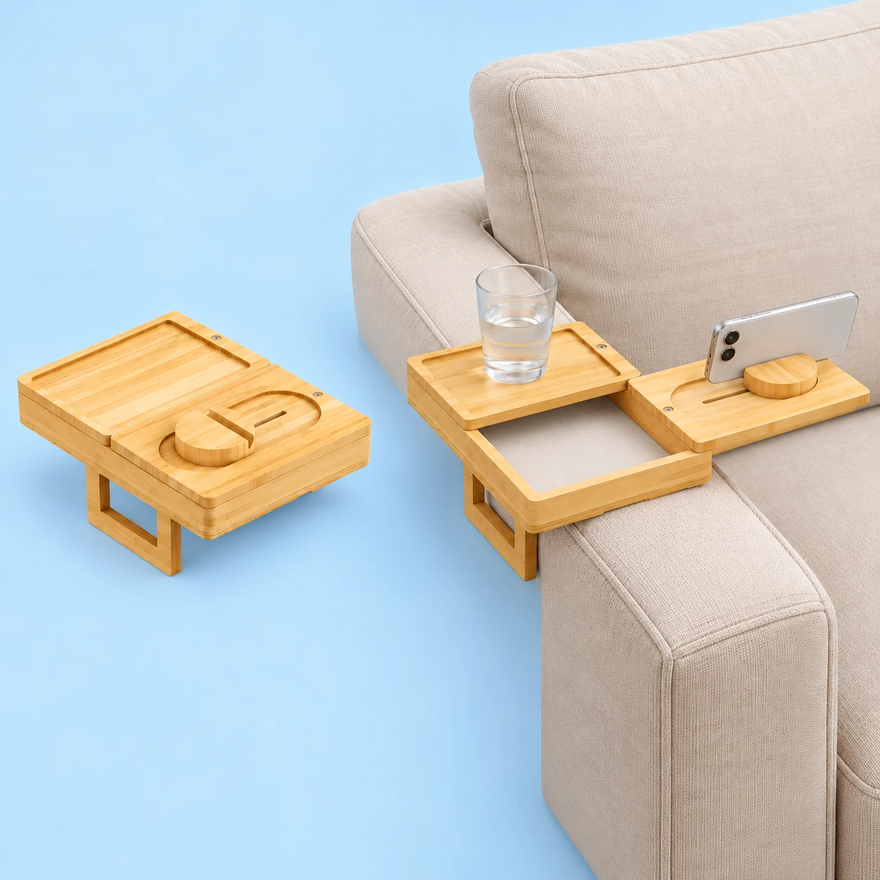 Complete natural bamboo sofa-arm storage tray closed and empty at left; the same original panels, circular phone slot, lined lower box and rectangular support in stationary sofa-arm use with a landscape phone and glass at right on pale blue. Props not included., square composition