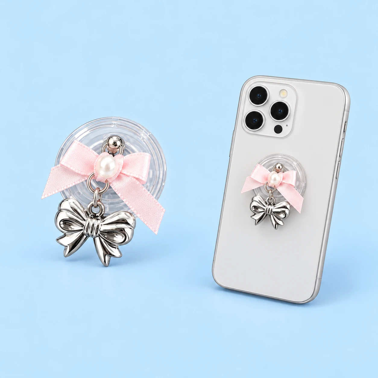 Pink satin-look ribbon phone grip with dangling silver-tone bow charm and closed mounting illustration, square composition