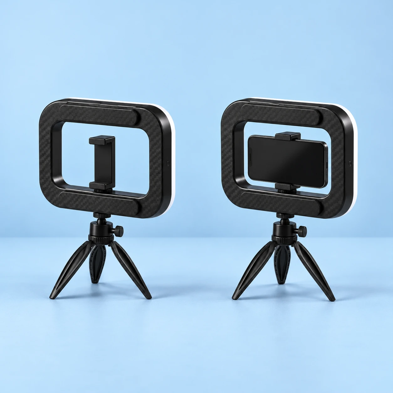 Complete black rounded-rectangular light-frame phone kit with its original empty lower-rim clamp, short ballhead and three-leg mini tripod at left; the same kit holds a stationary landscape demonstration phone at right on pale blue. Lamp off; phone not included., square composition