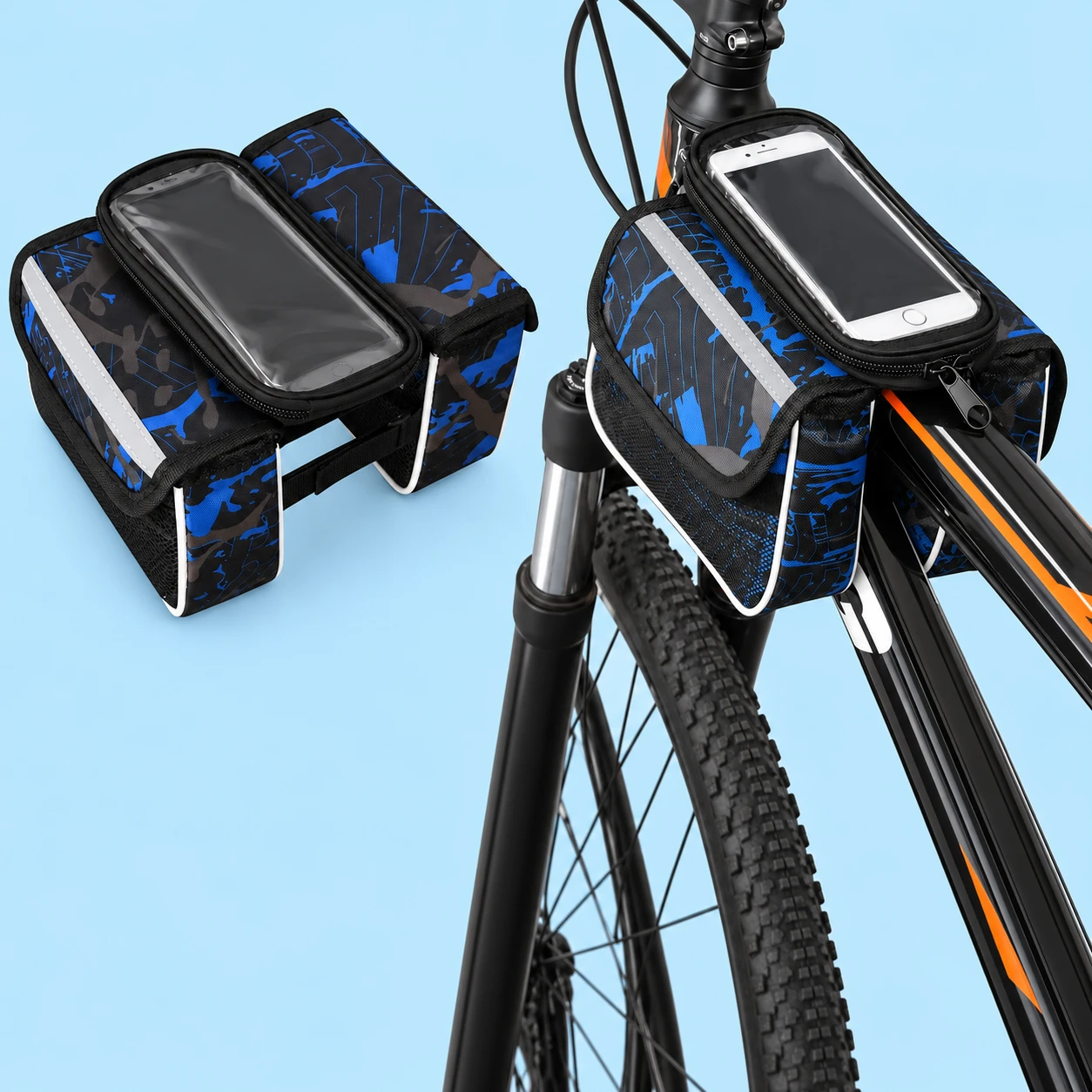Complete blue-and-black split-saddle bag with its flat phone-window pouch, two flap-topped side compartments and original visible lower textile band at left; the same bag straddling a stationary bicycle top tube at right, against pale blue. Both demonstration phones and bicycle are not included., square composition