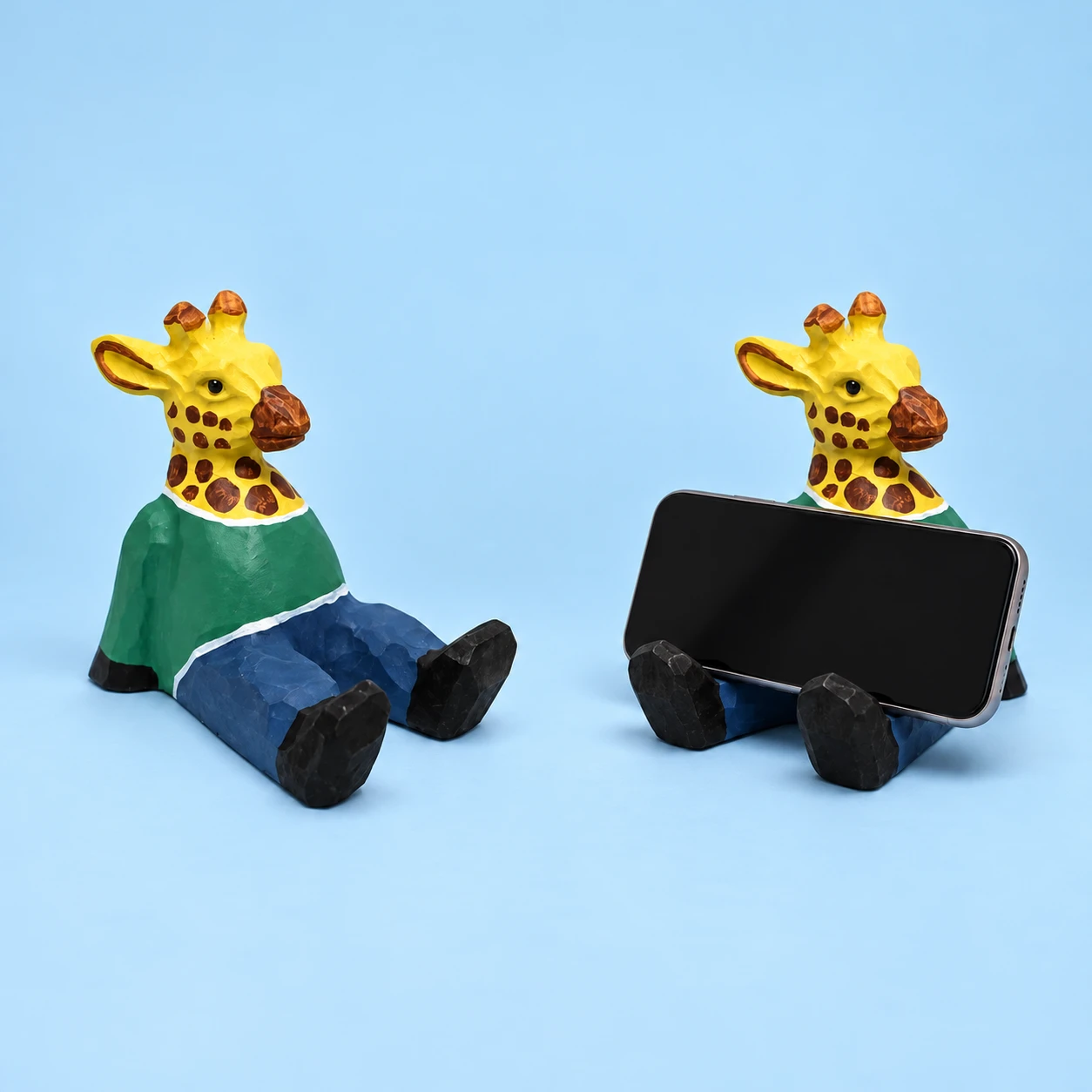 Seated green-shirt giraffe wooden phone rest and illustrative landscape phone support, square composition