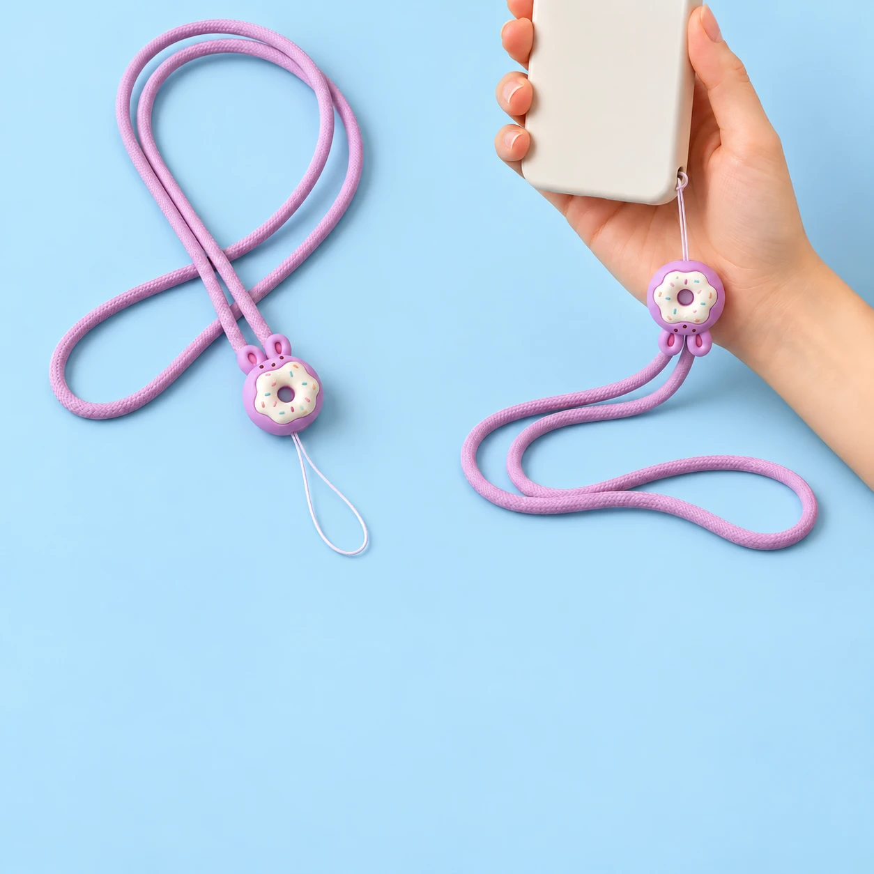 Lilac bunny donut neck phone lanyard shown complete and connected by its thin string loop to a phone-case eyelet, square composition