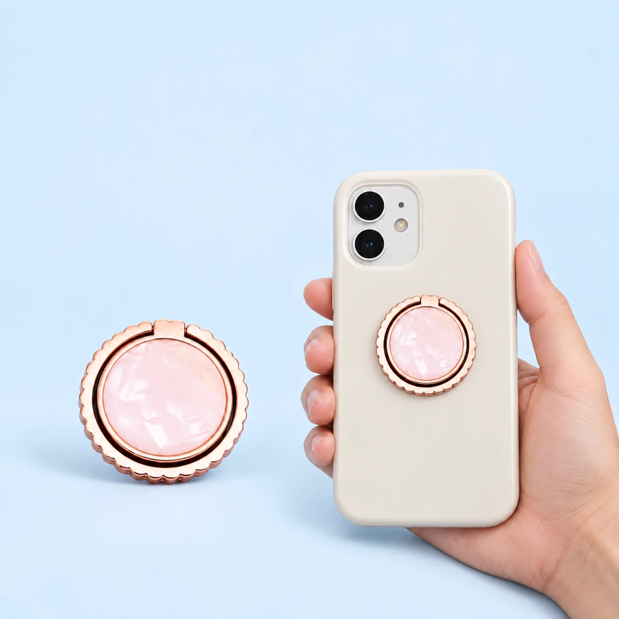 Rose-gold-tone scalloped phone ring with pink inlay, shown closed alone and on a phone case, square composition