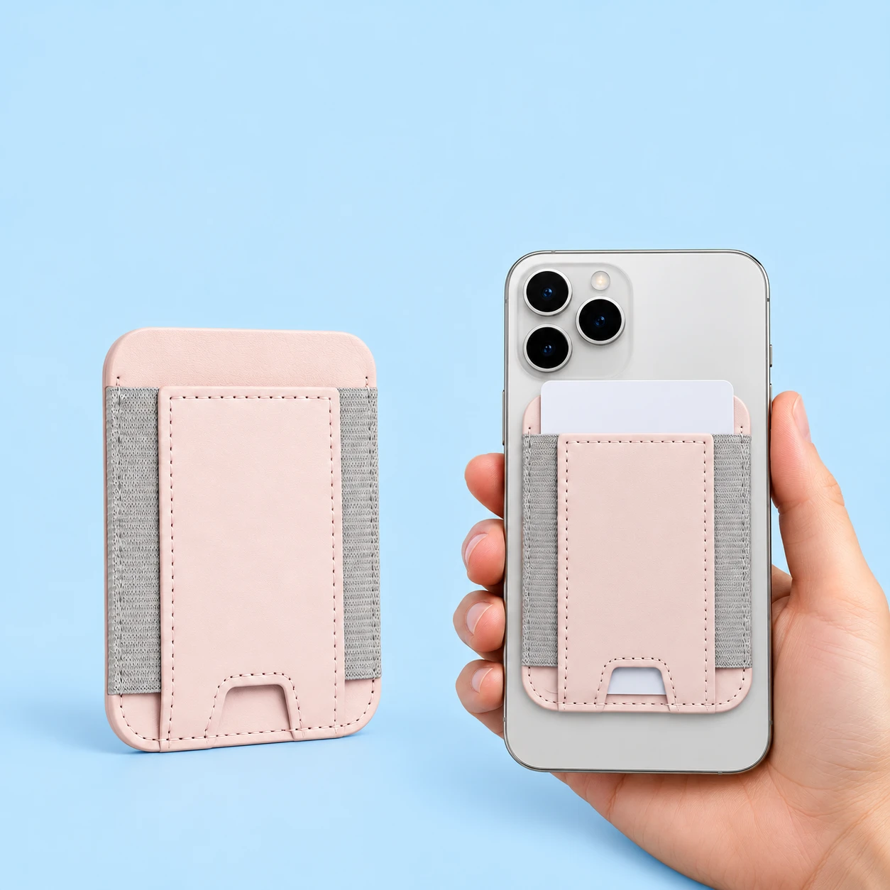 Pale-pink elastic-side magnetic phone card pocket shown empty at left and flat on a hand-supported phone with a blank demonstration card at right, against a pale-blue background. Phone and card are not included., square composition