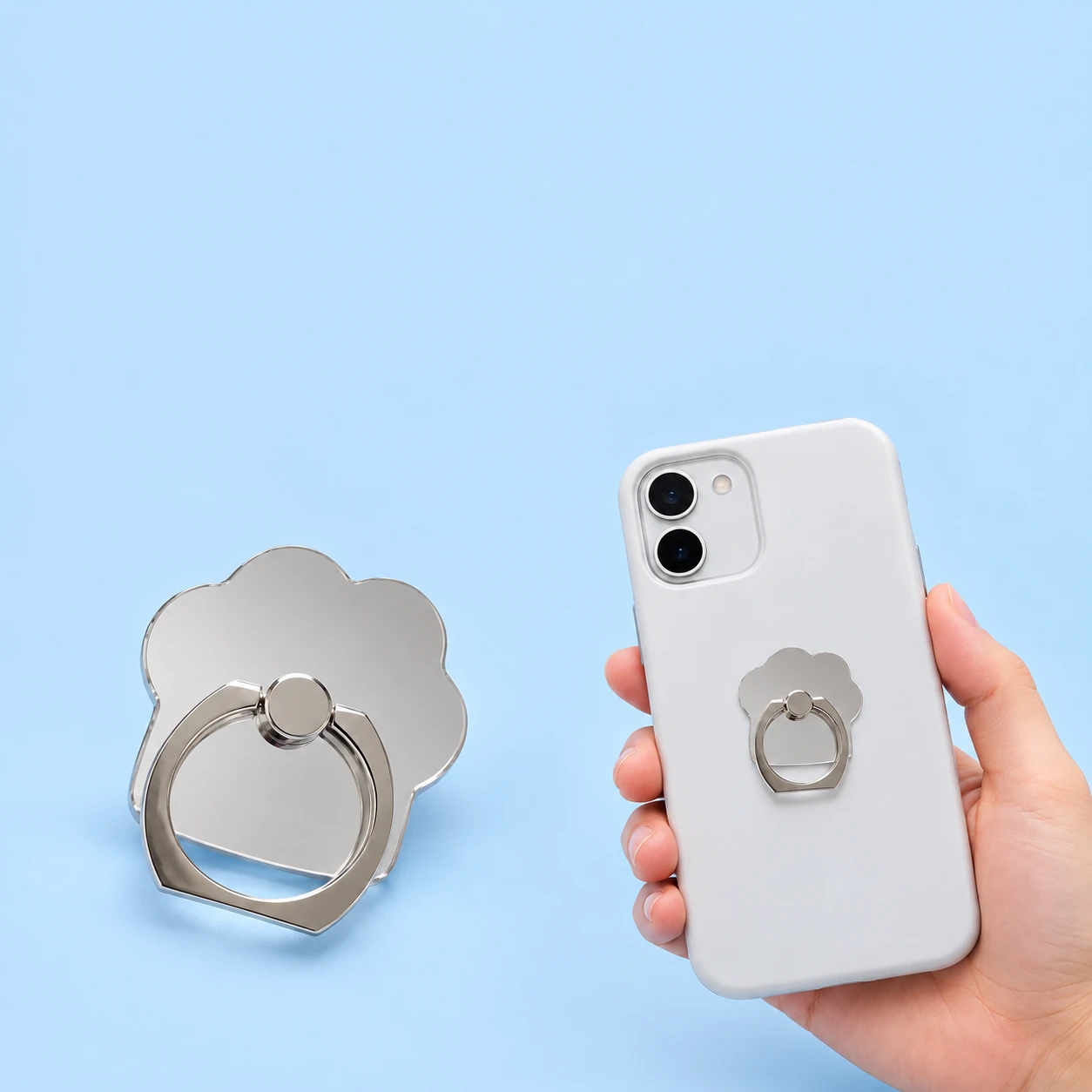 Mirrored cat-paw phone ring holder with hinged ring and conservative handheld phone-back placement, square composition
