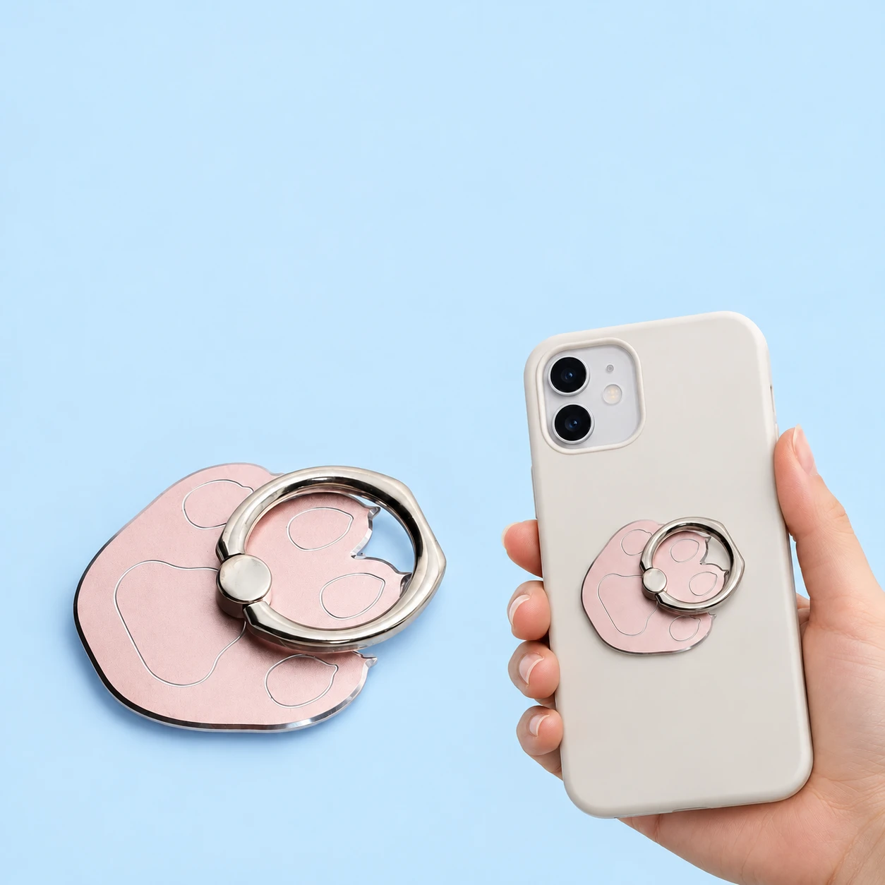 Rose-gold-tone broad-paw phone ring, complete and closed on a hand-supported phone, with rear fixing hidden, square composition