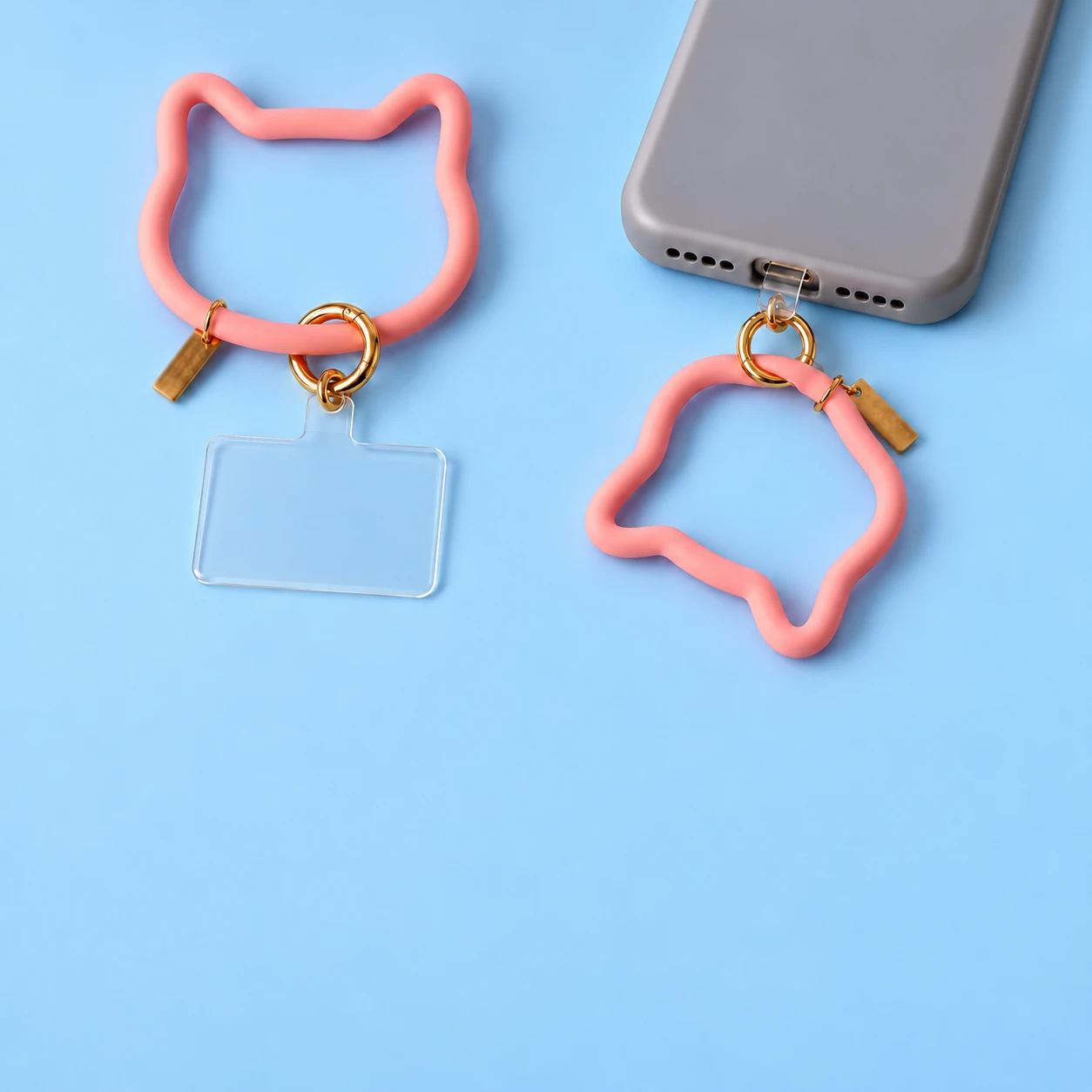 Pastel pink cat-outline silicone phone lanyard with clear tab and spring clasp, complete set and case attachment, square composition