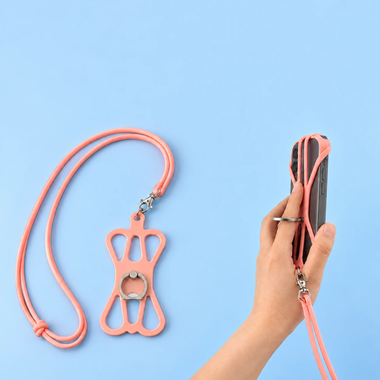 Pink silicone ring-cradle phone lanyard shown complete and with a finger through the central ring on a hand-supported phone, square composition