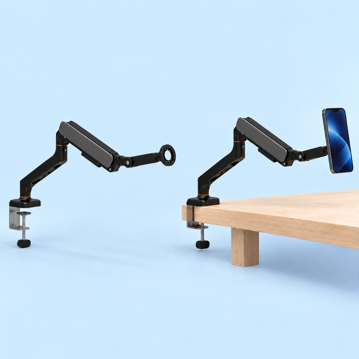 Complete black enclosed-arm magnetic phone holder with original silver screw desk clamp and empty open annular head at left; the same complete holder mounted to a wooden desk edge with an illustrative compatible portrait phone at right, on pale blue. Phone and desk not included., square composition