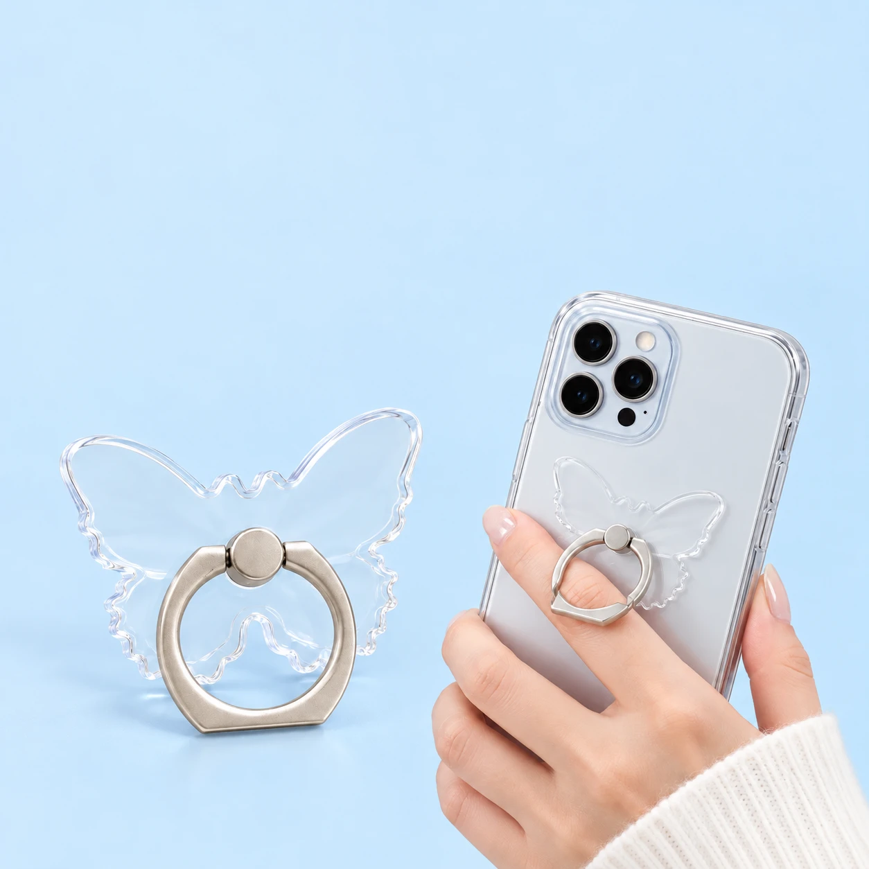 Clear butterfly phone ring holder shown complete and in finger-grip use on a phone case, square composition