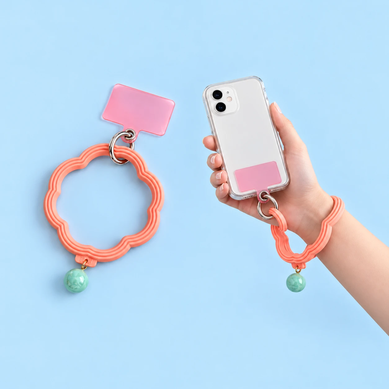 Coral pink scalloped flower wrist lanyard with mint charm and included pink case tab shown complete and worn on a wrist, square composition