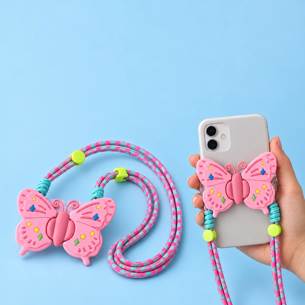 Pink folding butterfly clip-on phone lanyard with pink-turquoise cord and hand-supported phone use, square composition