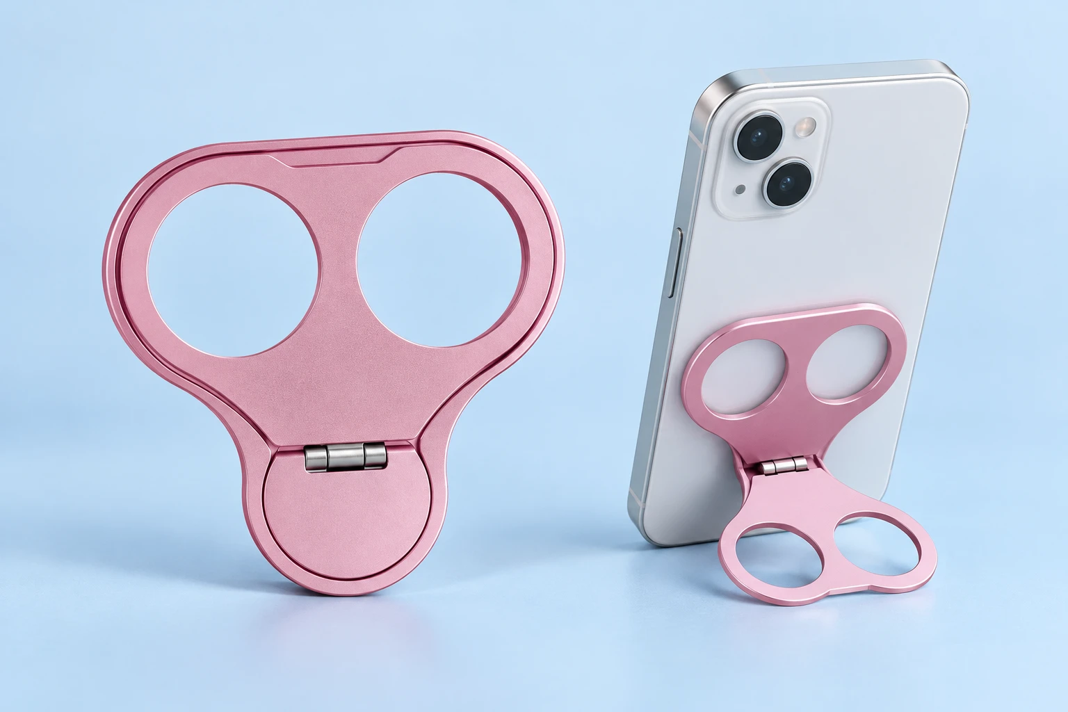 Pink double-hole folding phone grip and stand with illustrative tabletop phone use
