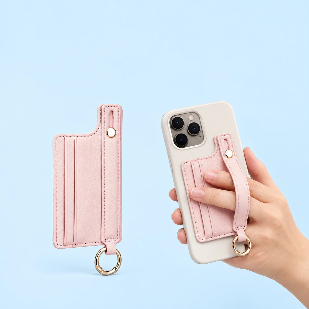 Pastel pink stepped phone card pocket with original sliding hand band and lower ring, shown complete and on a hand-supported phone, square composition