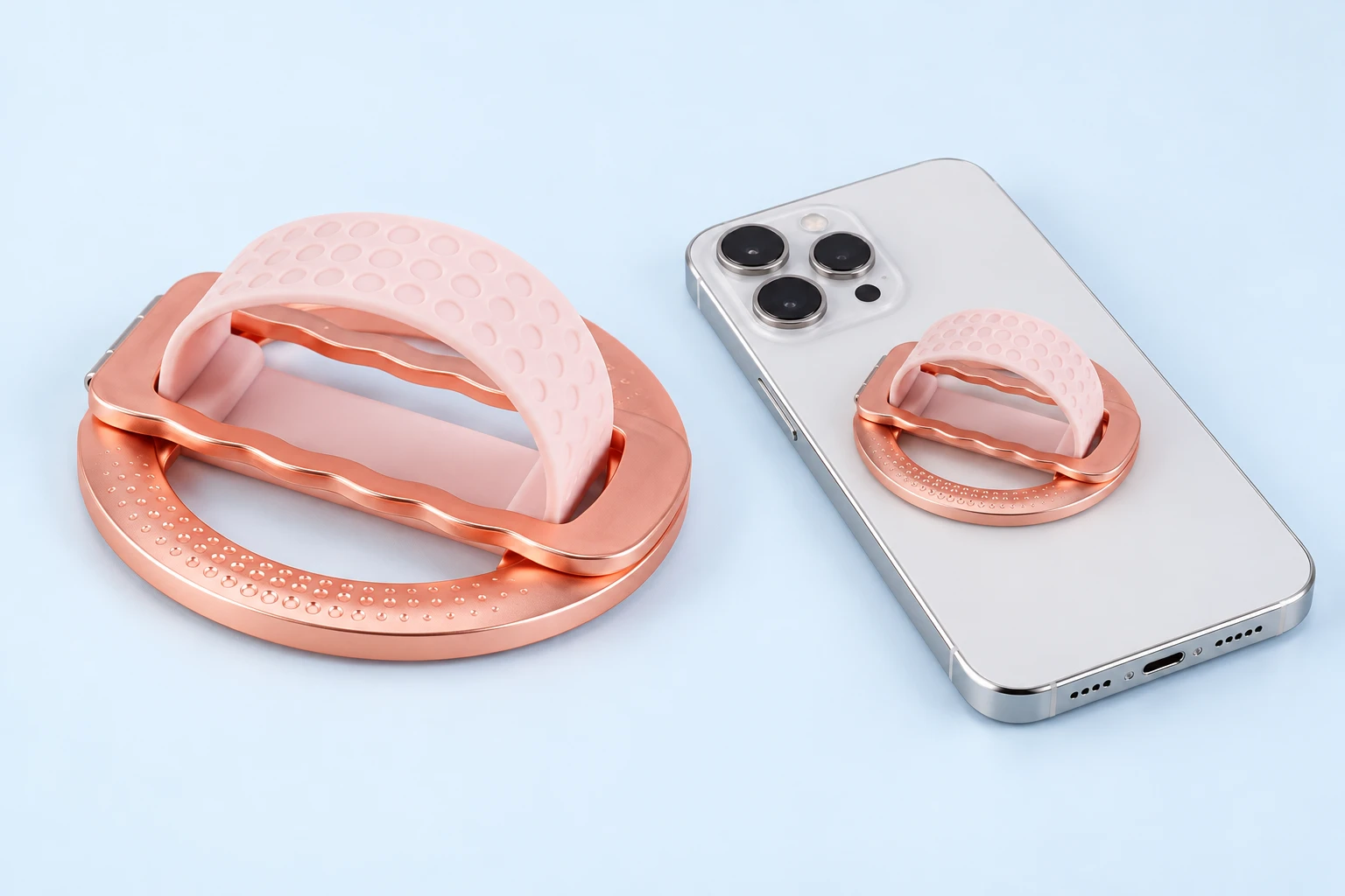 Rose-gold magnetic phone grip with pink dimpled band and mounted phone illustration