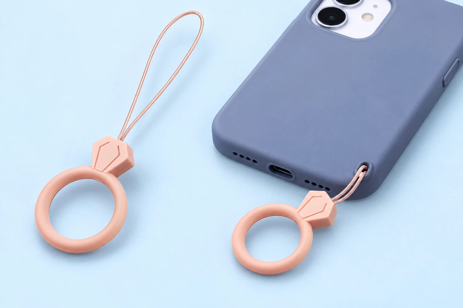 Sand pink gem-top finger-loop phone lanyard shown alone and attached through a phone-case eyelet