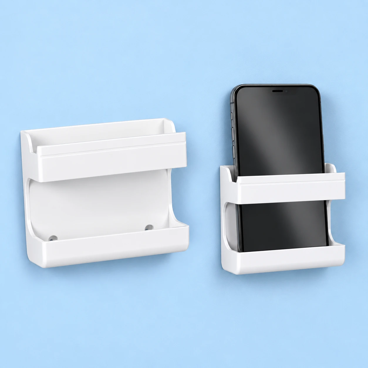 Complete empty white YK31 fence-frame wall phone holder on the left and the same original solid-back holder retaining a portrait phone behind its upper band and in its lower trough on a pale-blue wall on the right; phone is an illustration prop., square composition