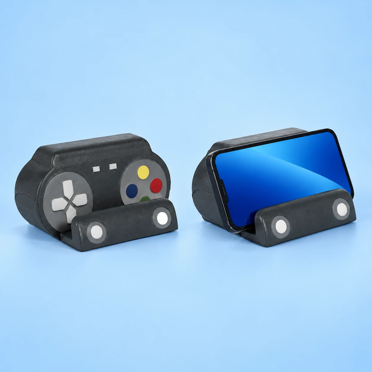 Black controller-shaped molded PU foam phone cradle, empty and with an illustrative landscape phone resting in its original seat, square composition