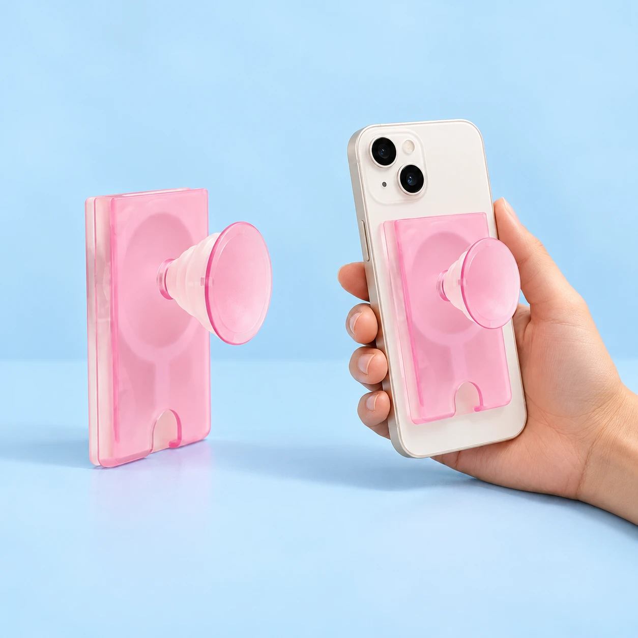 Translucent pink card-pocket phone grip with accordion stem and pink disc, shown alone and mounted on a phone, square composition