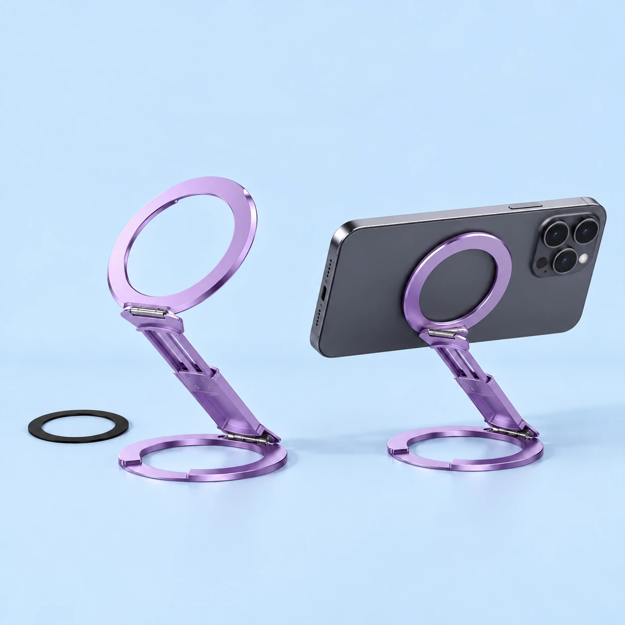 Complete lilac dual-ring magnetic phone stand with original slotted telescoping bridge and supplied receiver ring at left; the same stand supports a landscape demonstration phone from its rear center at right on pale blue., square composition