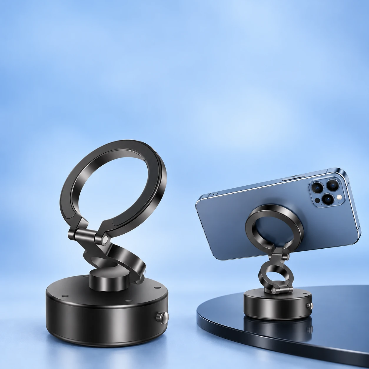 Complete empty black folding vacuum-base magnetic phone mount at left, and the same mount holding a compatible landscape phone on a stationary flat surface at right, on pale blue. Intended-use illustration; phone not included., square composition