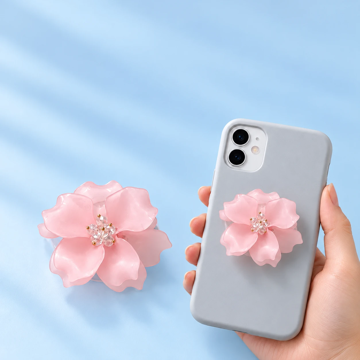Pastel pink layered camellia phone grip with transparent base and closed mounting illustration, square composition