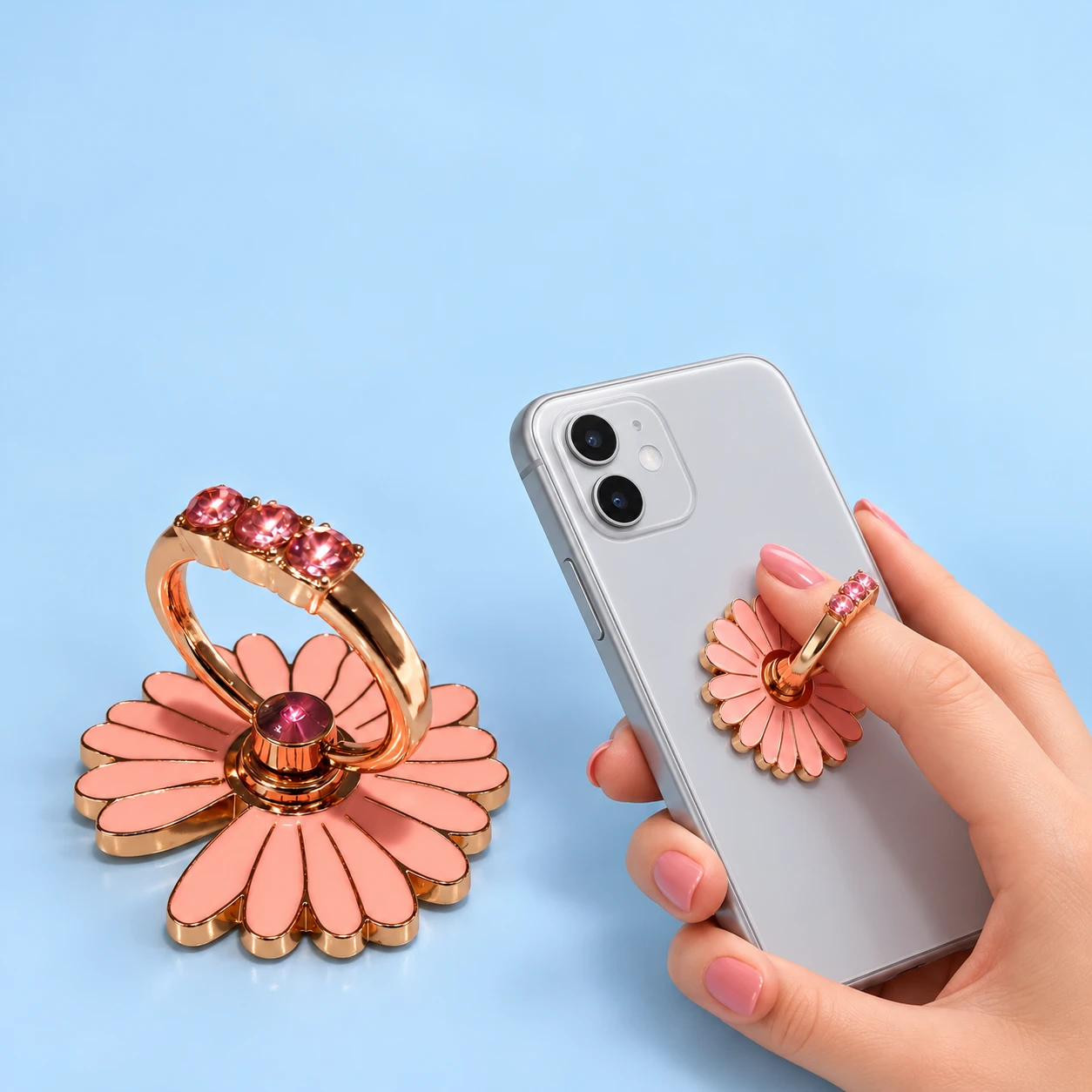 Pink daisy phone ring holder with decorative pink accents and illustrative finger use, square composition