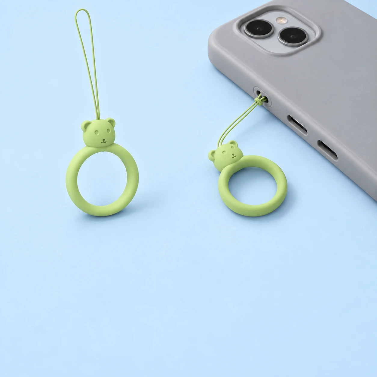 Matcha green bear-head finger-loop phone lanyard and direct case-eyelet attachment, square composition