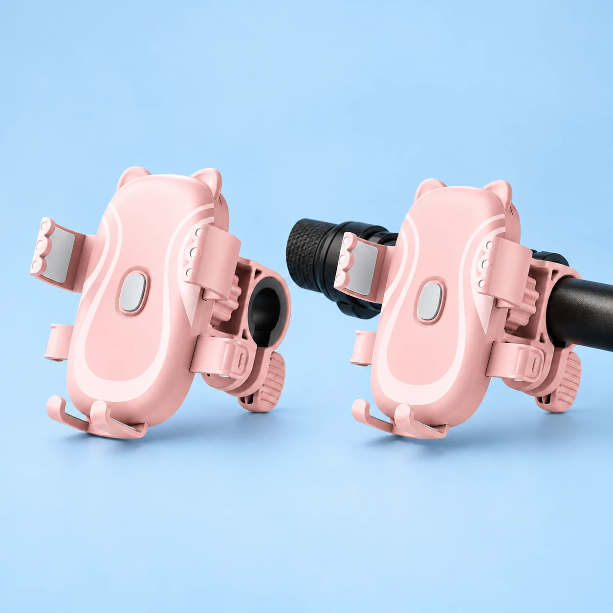 Pastel pink cat-ear phone cradle with handlebar clamp, shown empty on a stationary handlebar, square composition