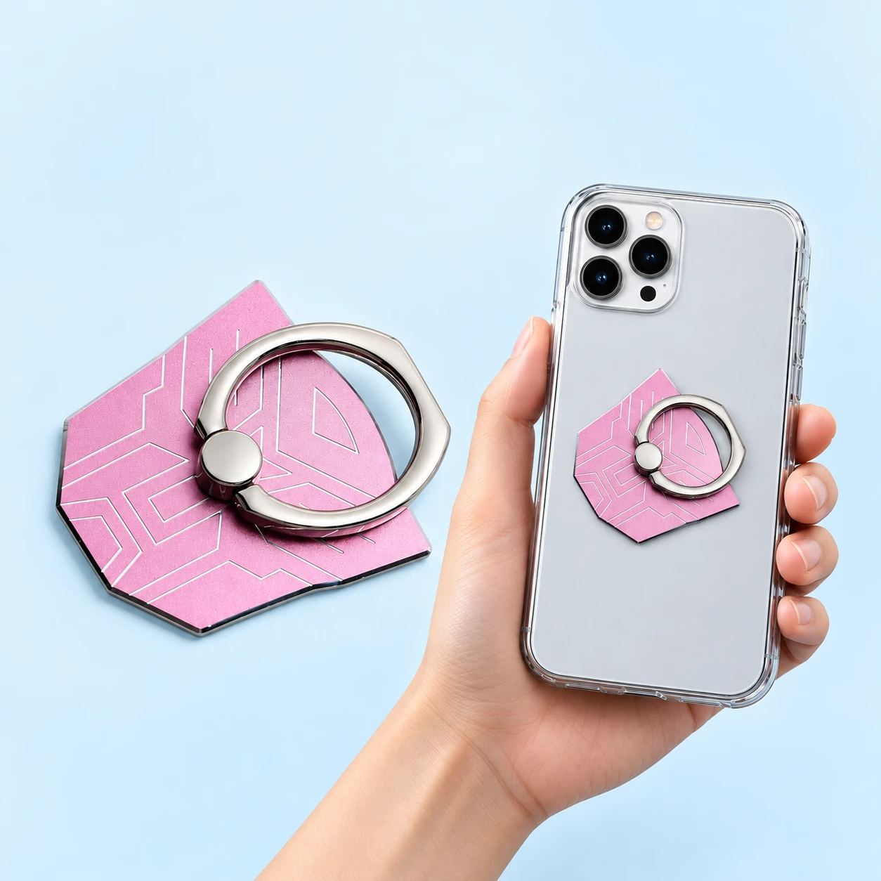 Pink angular-mask metal phone ring, complete and folded closed on a hand-supported phone with unseen rear attachment, square composition