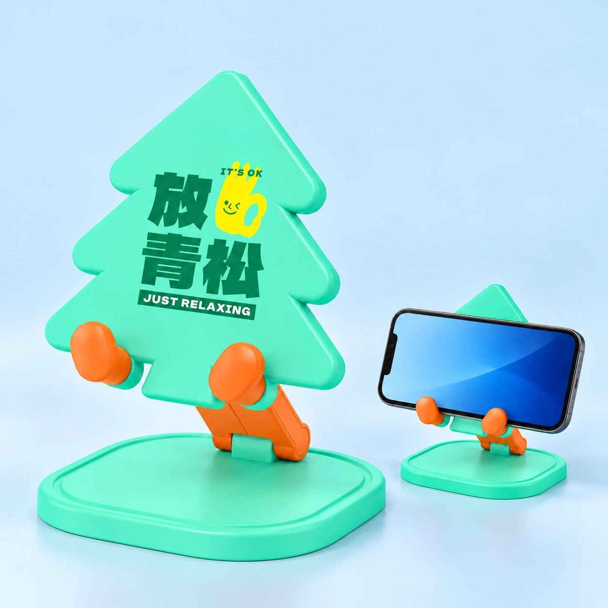 Mint Pine Tree Folding Phone Stand, complete stand left and landscape phone in cradle right on pale blue; phone not included