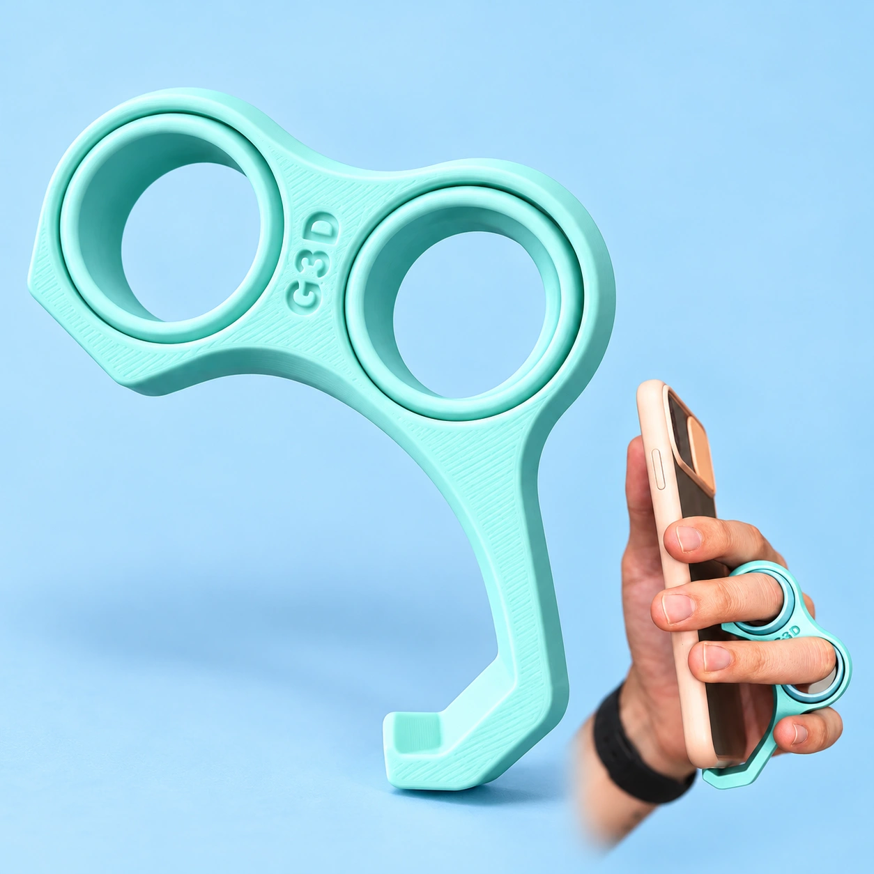 Soft mint twin-ring phone grip with curved bottom hook, shown complete and in hand with a phone