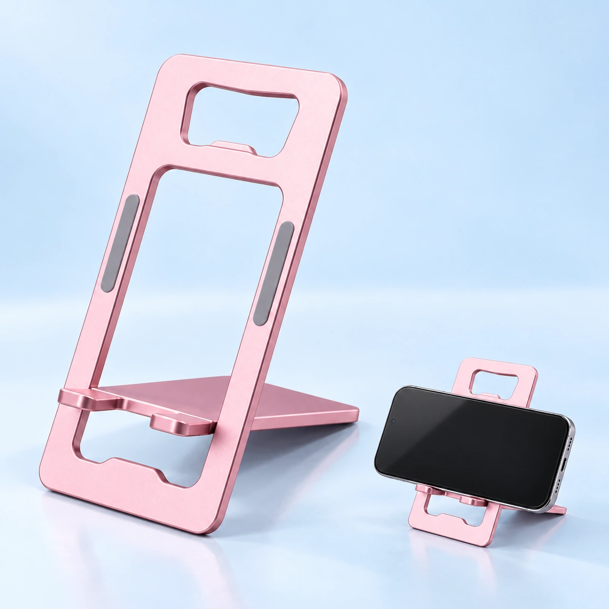 Pink card-frame folding phone stand shown complete and supporting a landscape phone