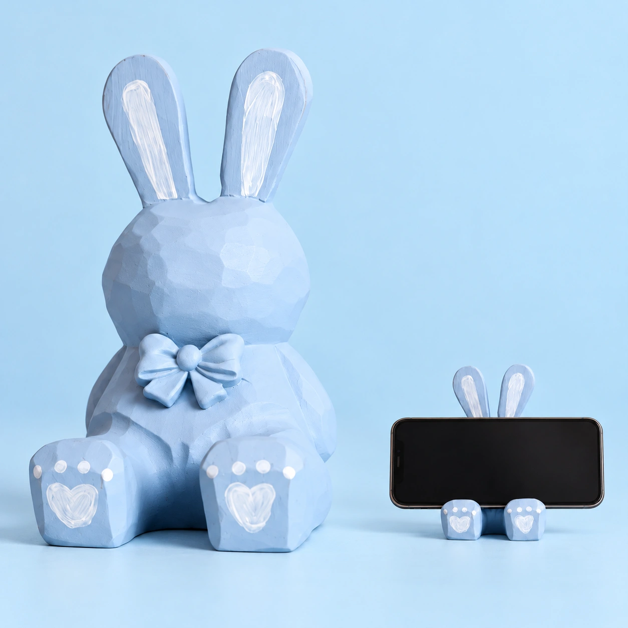 Pastel blue carved wooden rabbit phone stand and illustrative landscape-phone support