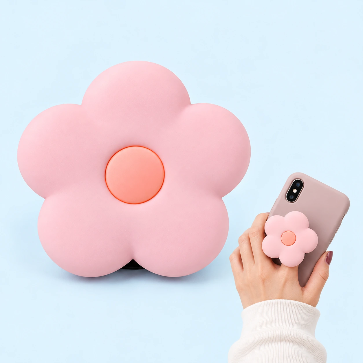Pastel pink five-petal silicone flower expandable phone grip with peach center and illustrative phone use