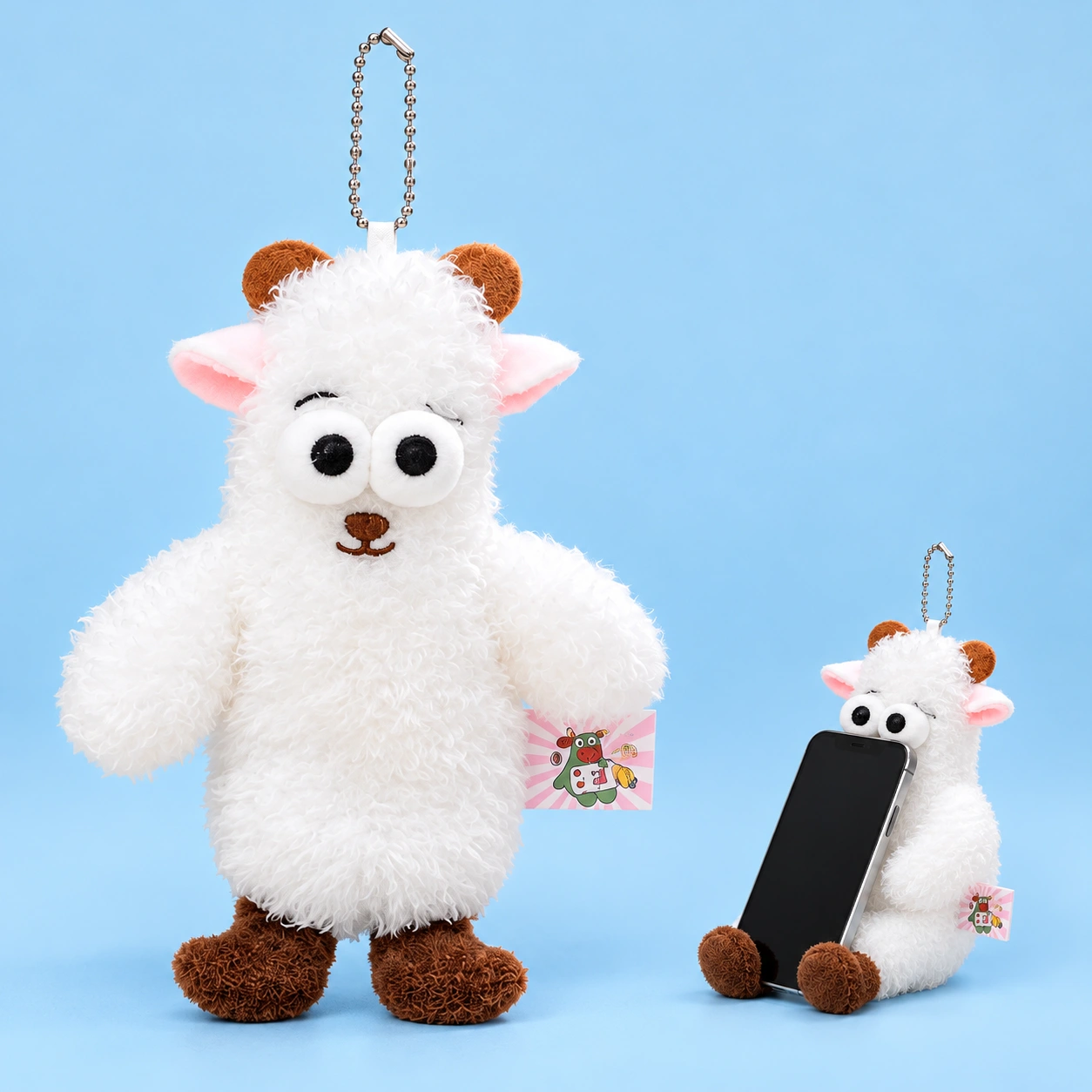 White horned sheep plush phone rest, shown complete and seated with a phone resting against its torso