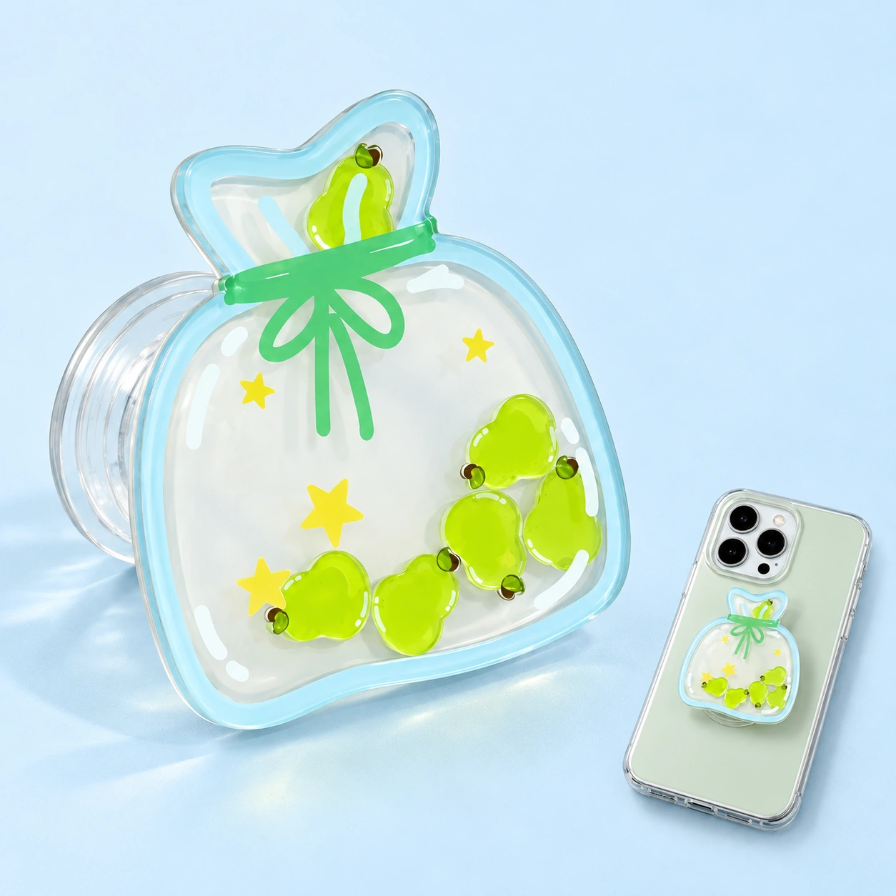 Green pear shaker-bag expandable phone grip with clear layered face and illustrative phone mounting