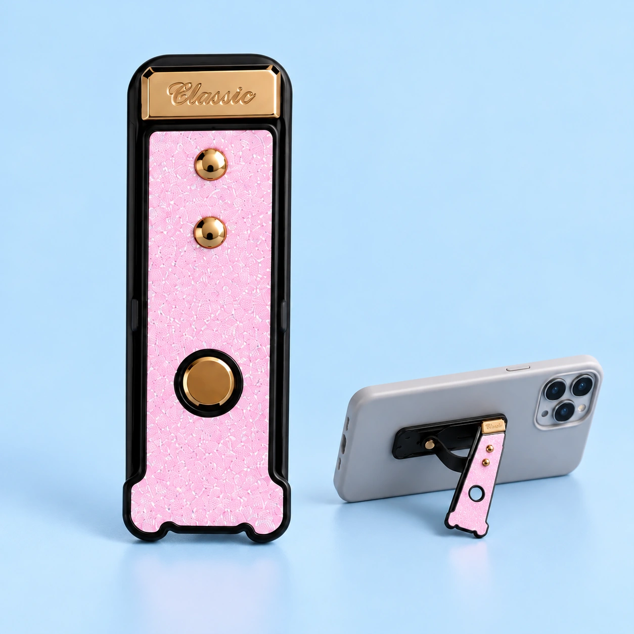 Pastel pink glitter flip-out phone grip stand, closed and supporting a landscape phone