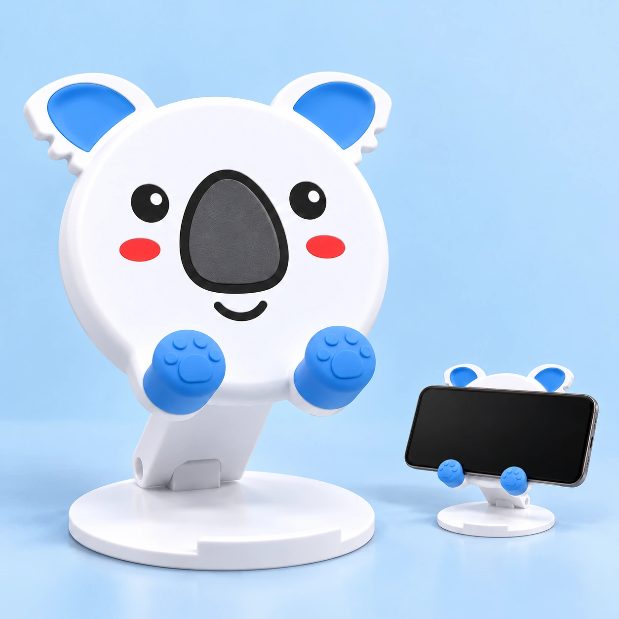 White and blue koala folding phone stand, complete stand left and landscape phone behind blue paw rests right; phone not included