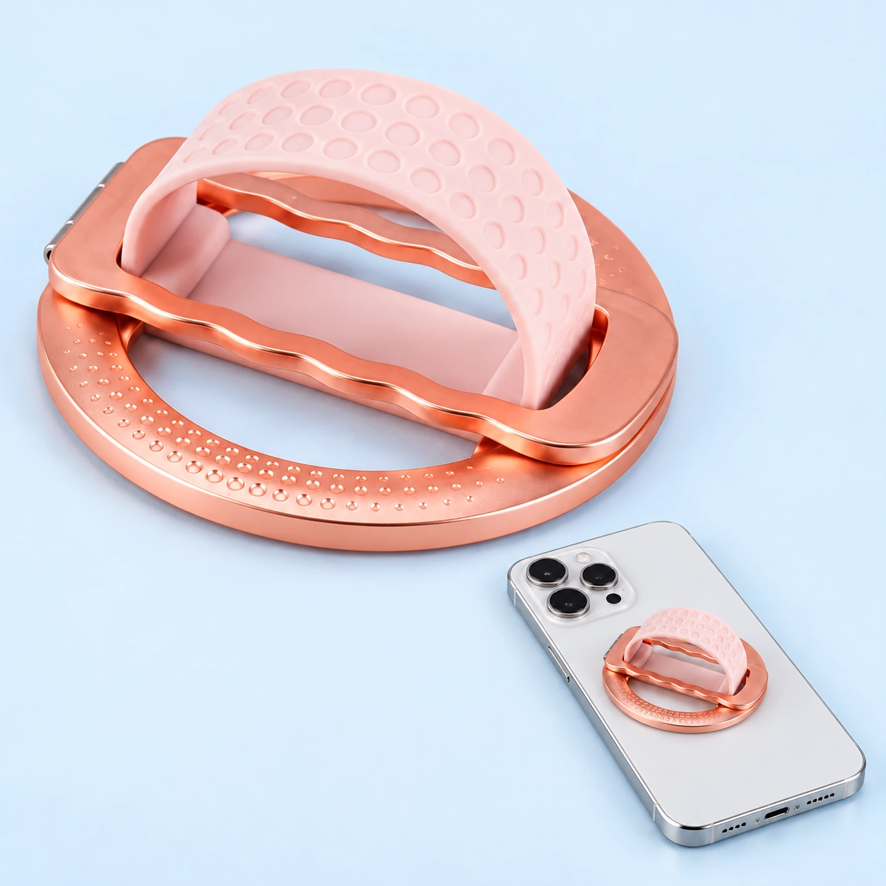 Rose-gold magnetic phone grip with pink dimpled band and mounted phone illustration