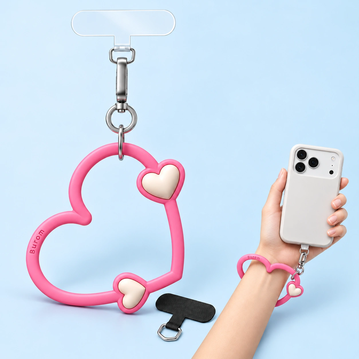 Bright pink heart-loop wrist phone lanyard shown complete with two tabs and in wrist-and-phone use
