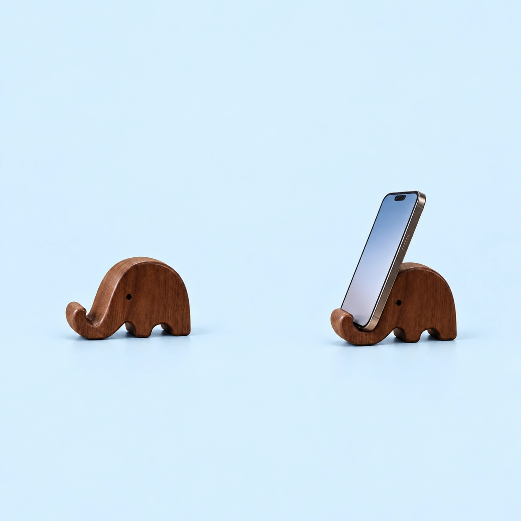 Dark Wood Elephant Phone Stand shown in use on a light blue background; demonstration device not included